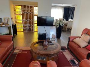 a living room with two couches and a tv at Ben Kalulu House in Mangeti