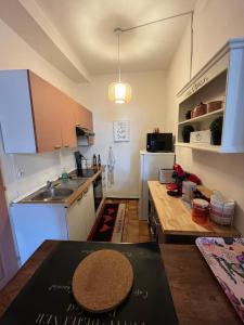 una pequeña cocina con mesa y encimera en Le Pink Lady Appartement centre historique de Bergerac, en Bergerac