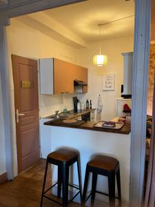 cocina con 2 taburetes y encimera en Le Pink Lady Appartement centre historique de Bergerac, en Bergerac 6 fotos más