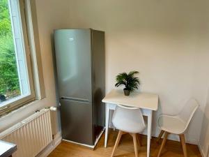 a small table and a refrigerator in a room at Leopold's Apartments mit Garten und Vesteblick Mitten in Coburg in Coburg