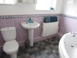 a pink bathroom with a toilet and a sink at Yarborough in East Cowes +11 photos