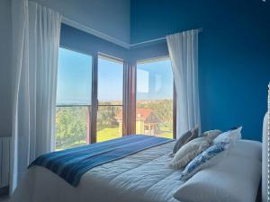 a blue bedroom with a bed and a large window at Vela Bianca - 12807 in Ajo