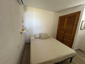 a small room with a bed and a wooden door at VALENTINA HOME Costa Smeralda Vista Mar in Cugnana Verde +8 photos