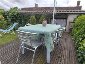 ein Tisch und Stühle auf einer Terrasse mit Sonnenschirm in der Unterkunft Rosemary Cottage in Sergines