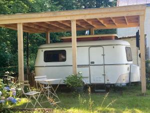 a white rv under a canopy in a yard at La Clairicourrière in Mignault