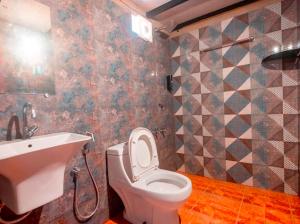 a bathroom with a white toilet and a sink at Taya Beach Front in Gokarna