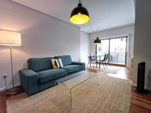 salon z niebieską kanapą i szklanym stolikiem kawowym w obiekcie 4J - Ourense Centro con parking w mieście Ourense