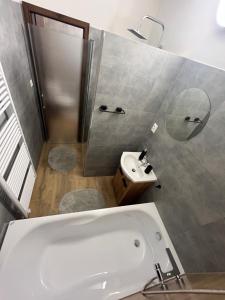 a bathroom with a white tub and a sink at Garni Hotel Tatramonti in Poprad