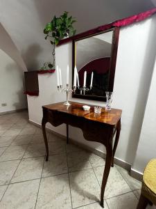 a wooden table with a mirror and candles on it at Carmelinas home in Belpasso +33 photos