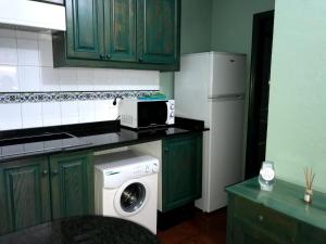 a kitchen with a washing machine and a refrigerator at Casa El Pajar 1 in El Pinar del Hierro