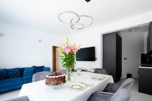 a dining room with a table with a cake on it at Two bedroom apartment Karmen with pool in Sinj