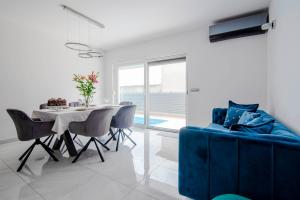 a living room with a blue couch and a table at Two bedroom apartment Karmen with pool in Sinj