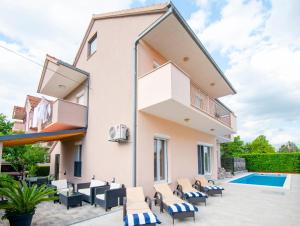 a villa with a swimming pool and a house at Two bedroom apartment Karmen with pool in Sinj