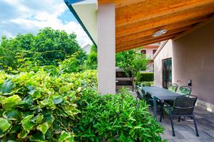 a patio with a table and chairs and plants at Two bedroom apartment Karmen with pool in Sinj