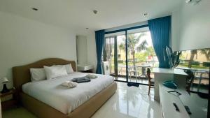 Ban Ao MakhamPixel - Studio Cape Panwa Ocean Front Partial Seaview的一间带床的卧室，可欣赏阳台景色
