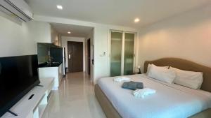 Ban Ao MakhamPixel - Studio Cape Panwa Ocean Front Partial Seaview的卧室里有一张床，床上有一台电视和一本书