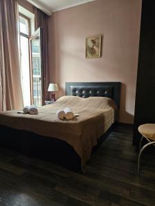 a bedroom with a bed with two towels on it at Comfy Nook Apartment in Tbilisi City
