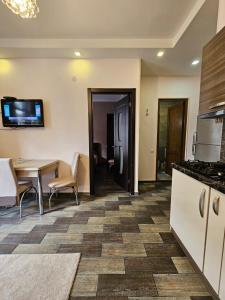 a room with a kitchen with a table and a counter at Comfy Nook Apartment in Tbilisi City +1 photo