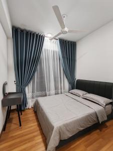 a bedroom with a bed and a window with blue drapes at De Suria Suite IOI Resort City in Putrajaya