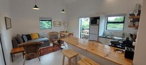 eine Küche und ein Wohnzimmer mit einem Holztisch in der Unterkunft Wild Plum Cottage in Kei-mouth Village