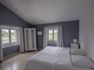 a bedroom with a large bed and two windows at Est in Colonzelle +19 photos
