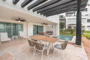 a patio with a table and chairs and a pool at Apt with picuzzi in Cap Cana at Punta Palmera BA5 in Punta Cana