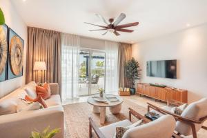 a living room with a couch and a tv at Apt with picuzzi in Cap Cana at Punta Palmera BA5 in Punta Cana