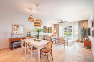 a dining room and living room with a table and chairs at Apt with picuzzi in Cap Cana at Punta Palmera BA5 in Punta Cana