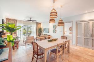 a dining room and living room with a table and chairs at Apt with picuzzi in Cap Cana at Punta Palmera BA5 in Punta Cana