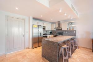 a kitchen with a large island with bar stools at Apt with picuzzi in Cap Cana at Punta Palmera BA5 in Punta Cana