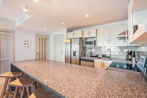 a kitchen with a granite counter top and wooden stools at Apt with picuzzi in Cap Cana at Punta Palmera BA5 in Punta Cana