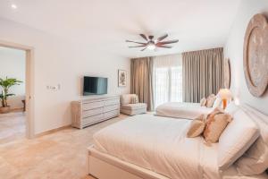 a bedroom with two beds and a flat screen tv at Apt with picuzzi in Cap Cana at Punta Palmera BA5 in Punta Cana