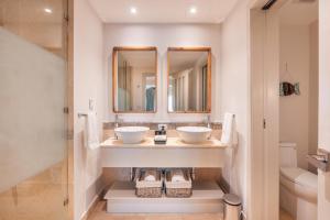 a bathroom with two sinks and a mirror at Apt with picuzzi in Cap Cana at Punta Palmera BA5 in Punta Cana