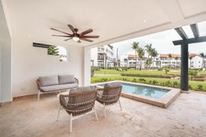 a living room with a ceiling fan and a pool at Apt with picuzzi in Cap Cana at Punta Palmera BA5 in Punta Cana
