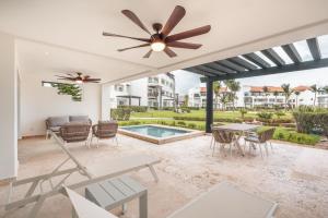 a patio with a table and chairs and a ceiling fan at Apt with picuzzi in Cap Cana at Punta Palmera BA5 in Punta Cana