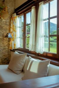 a bed with pillows in a room with a window at El Molino de Bonaco in San Vicente de la Barquera