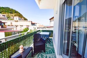 a balcony with a table and chairs on a building at Ekaterina house 2 minuti dal mare in Brolo