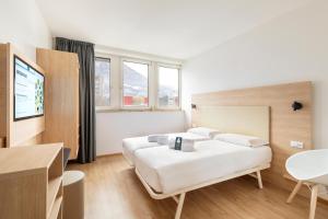 a hotel room with a bed and a tv at B&B Hotel Bolzano in Bolzano