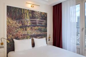 a bedroom with a large painting above a bed at Timhotel Tour Montparnasse in Paris