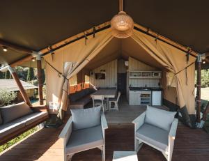 ein Zelt mit Stühlen, einem Tisch und einer Küche in der Unterkunft Glamping Le Tegole in Riparbella