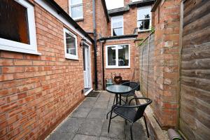 a small patio with two chairs and a table at Wisteria Cottage Town Centre FREE PARKING in Stratford-upon-Avon
