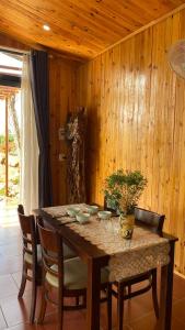 un tavolo da pranzo con sedie e una parete in legno di Home of bong & gao a B'su M'rac