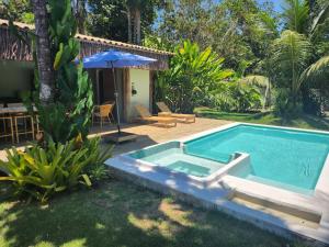 a swimming pool in a yard with a house at Suíte Caju - Conforto e Exclusividade em Trancoso in Trancoso