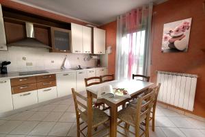 a kitchen with a table and chairs in a room at Affitto Breve Rovigo La Casa sul Grande Fiume Po di Nadine in Guarda Veneta