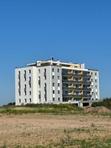 a large white apartment building on the beach at Apartament Magnacka Barczewski Dwór in Barczewo