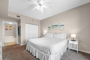 une chambre blanche avec un lit et un ventilateur de plafond dans l'établissement Windemere Unit 1006, à Pensacola 46 autres photos
