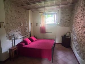 a bedroom with a bed with pink sheets and a window at Agriturismo I Melograni in Ferentillo +55 photos