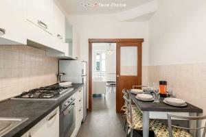 a kitchen with a stove and a table with chairs at Luci Danzanti, Terre Marine in Riomaggiore +8 photos