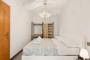 a white bedroom with a bed and a chandelier at Luci Danzanti, Terre Marine in Riomaggiore