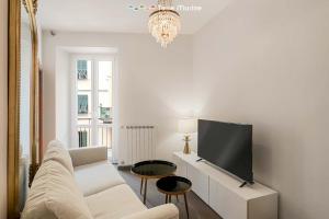 a living room with a white couch and a flat screen tv at Luci Danzanti, Terre Marine in Riomaggiore